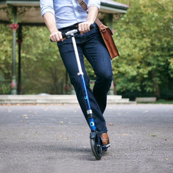 Mężczyzna na hulajnodze Micro Flex wracający z pracy