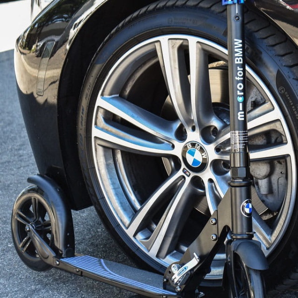 hulajnoga dla młodzieży i dorosłych Micro BMW City zaparkowana przy BMW