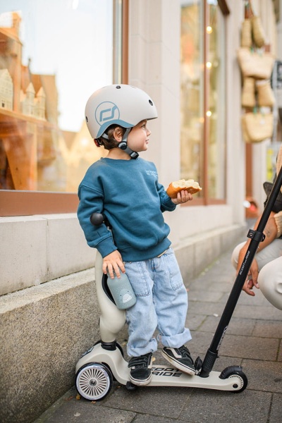 dziecko stoi na jeździku Scoot And Ride Highwaykick 1 Push and Go z rączką do prowadzenia Ash